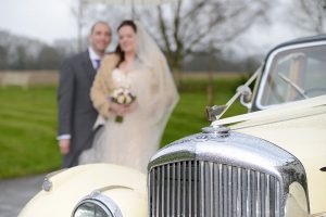 Bride and Groom with a vintage car