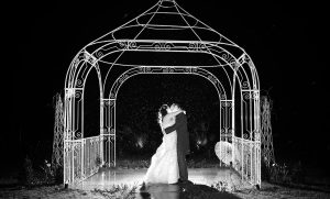 Bride and Groom night time shot in the rain at Southdowns manor