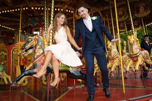 Wedding guests having fun at Carter's Steam Fair on the gallopers
